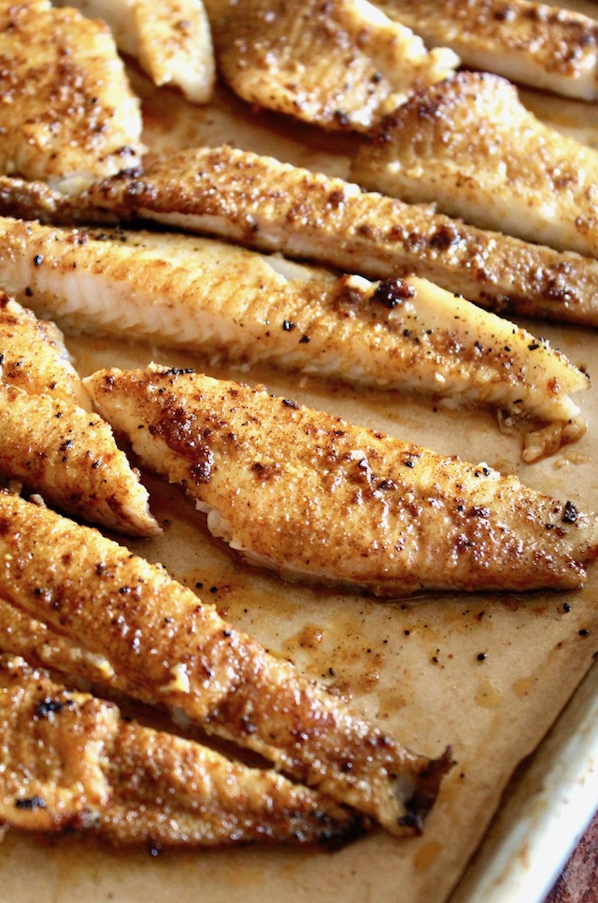 Pieces of blackened sole fillets for tacos, on parchment paper.