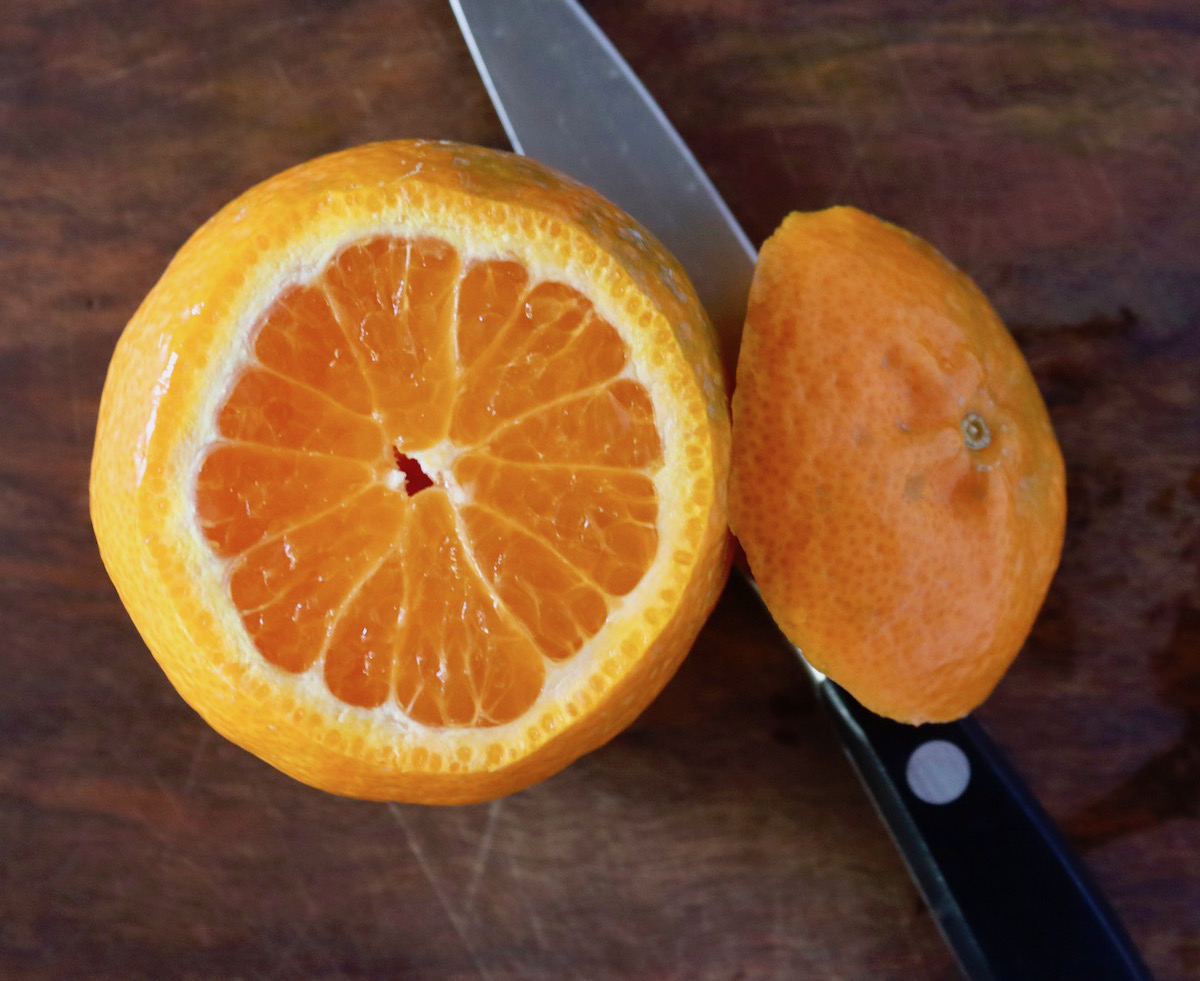 Top view of a tangerine with the top inch cut off.