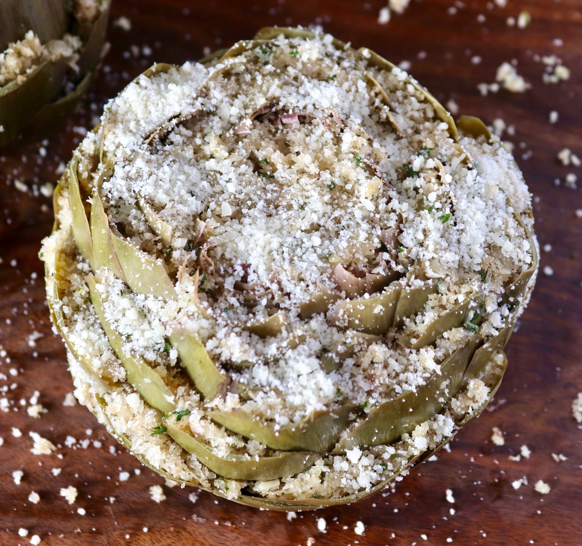 Top view of big artichoke with breadcrumb stuffing and Parmesan cheese.